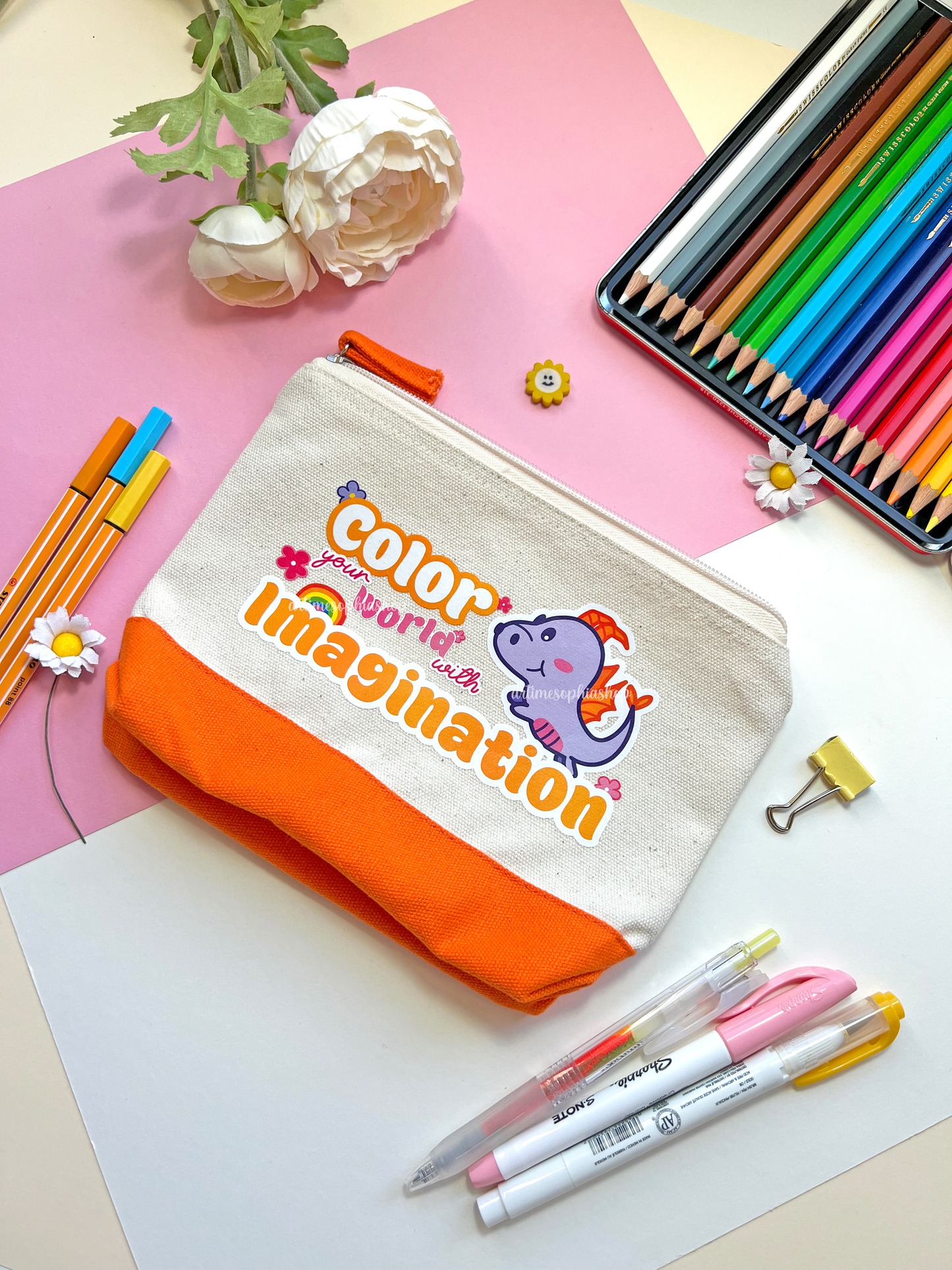 Cotton accessories pouch with a Figment illustration and the quote “Color Your World With Imagination”, featuring a bright orange stripe. Ideal for pens, pencils, and small creative items.