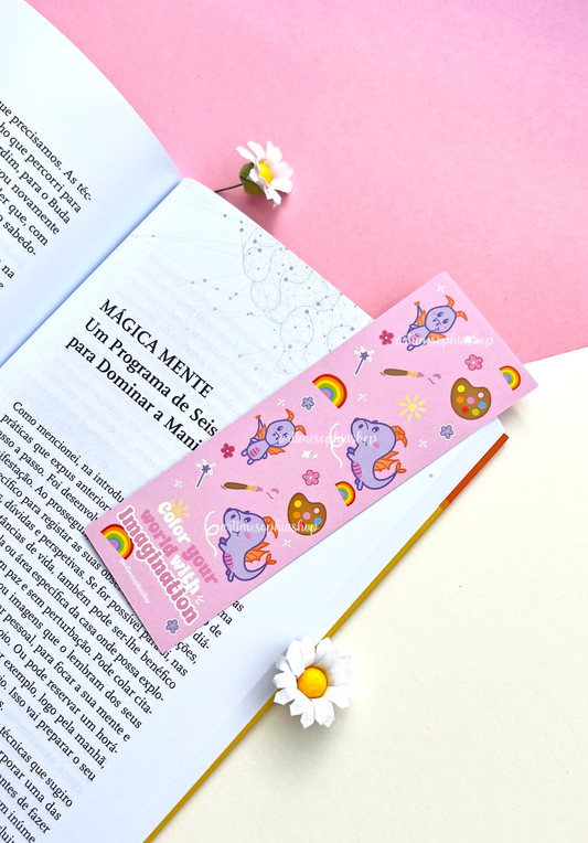 Double-sided lilac and pink bookmark featuring Figment surrounded by flowers, rainbow colors, and art supplies, with the phrase “Color your world with imagination” on the back.