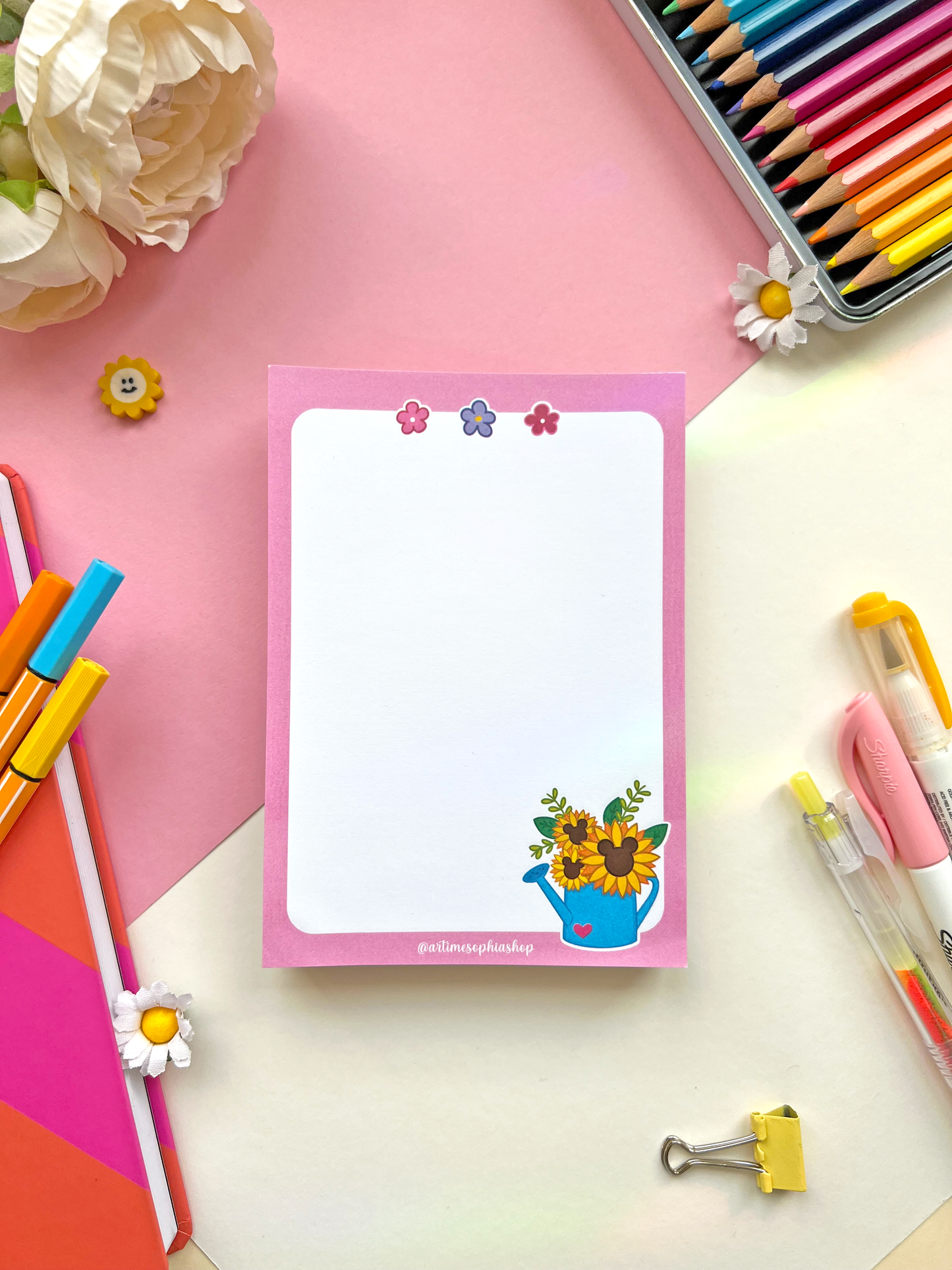A6 notepad with a soft pink background and a sunflower-filled watering can, paired with the phrase “Give Yourself Time To Bloom” — ideal for notes or journaling.
