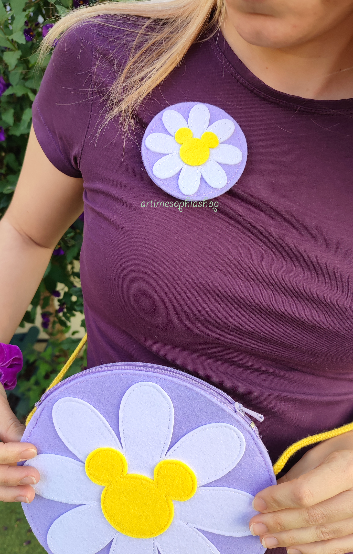 Handmade felt Daisy flower with Mickey-shaped center on a lilac base. Customisable accessory for Disney Bounds — use as a magnet, hairclip, keychain, or pin.
