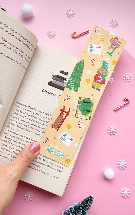 Illustrated Christmas bookmark with Elf Ellie, a vintage post office, and magical details, available in soft pink or cheerful yellow.