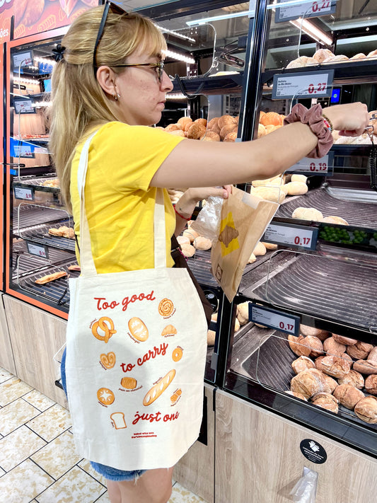 Tote bag illustrated with breads and pastries surrounding the phrase "Too Good to Carry Just One". Perfect fot bakery lovers.