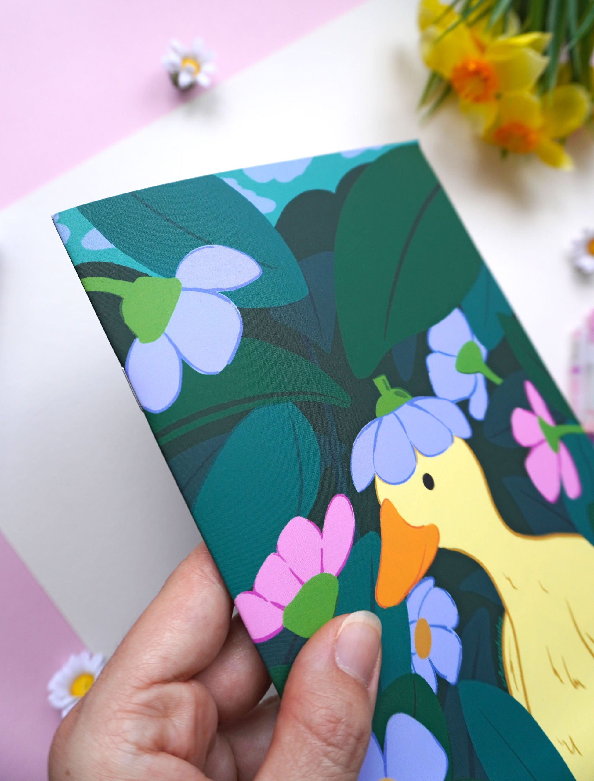 Soft-touch notebook featuring a duck surrounded by flowers and garden greenery