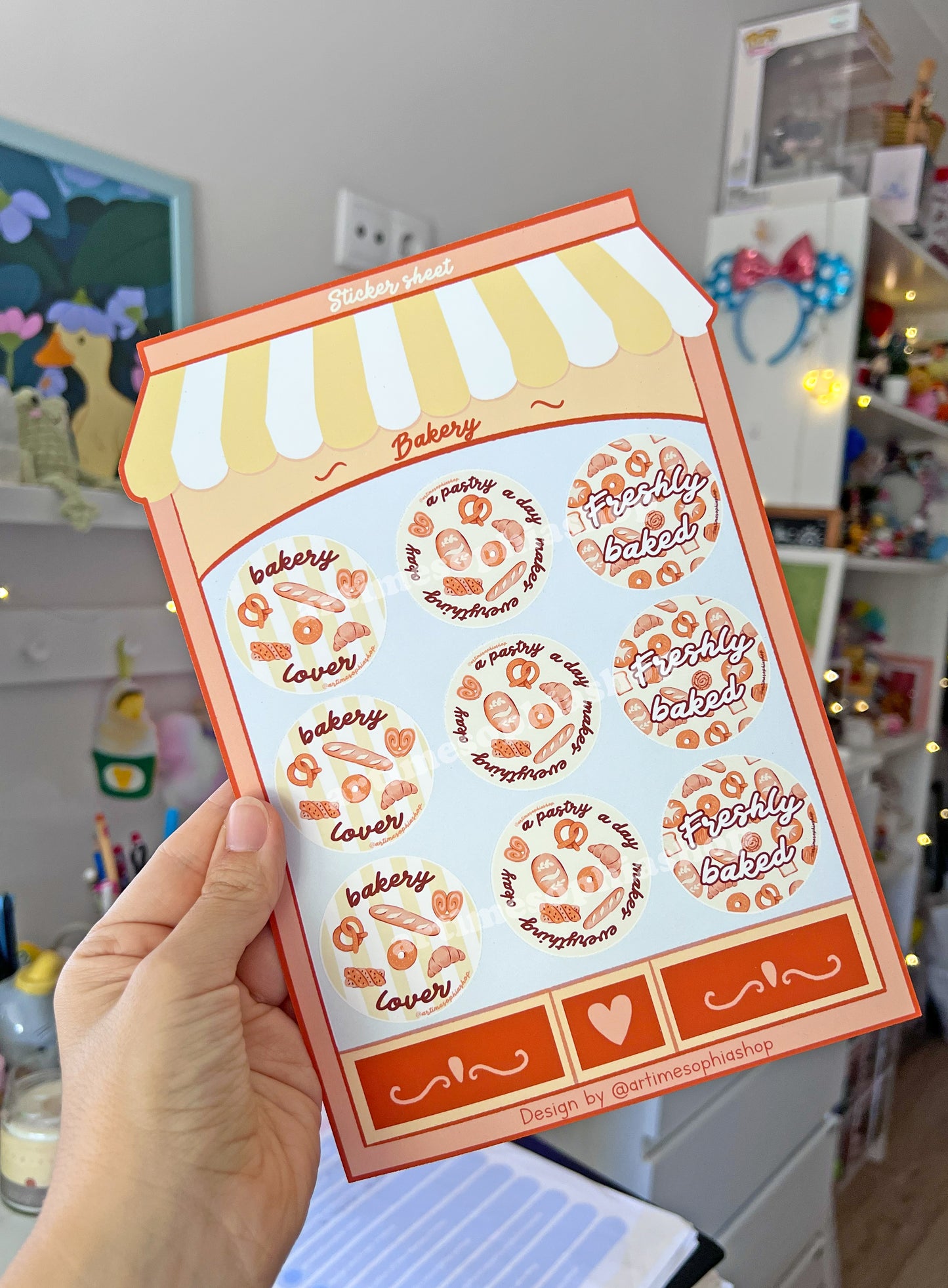 Large bakery-themed sticker sheet designed like a bakery storefront with nine round illustrated labels featuring bakery-inspired phrases.